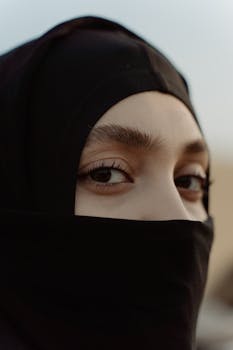 A captivating close-up shot of a woman in a black hijab, showcasing her expressive eyes.