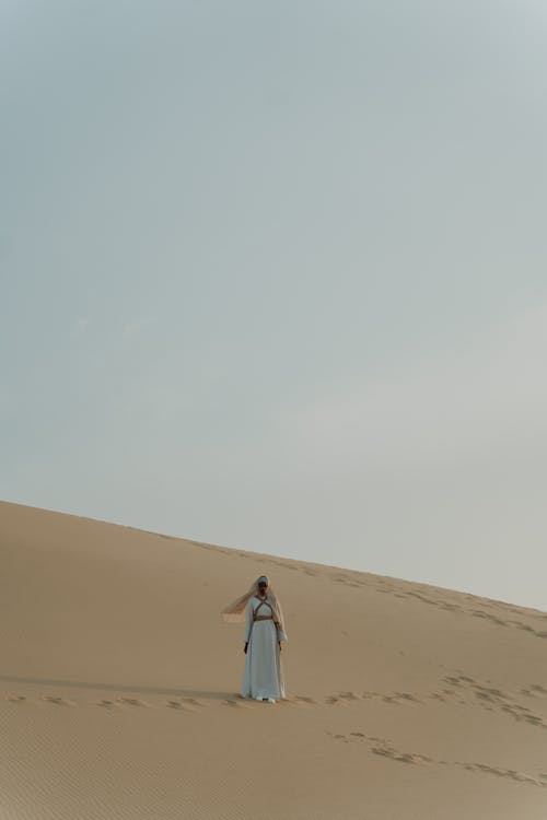 Woman in White Dress Standing on a Desert