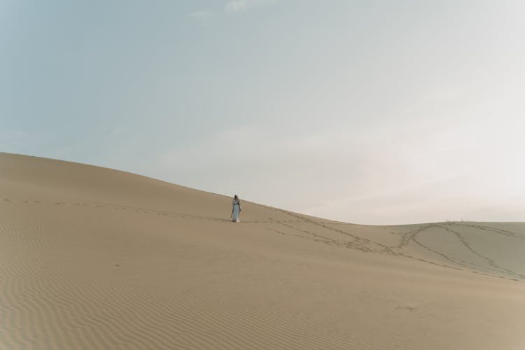 A Person Walking At The Desert