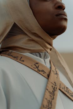 Close-up of a woman wearing a headscarf with Arabic calligraphy, showcasing cultural elegance.