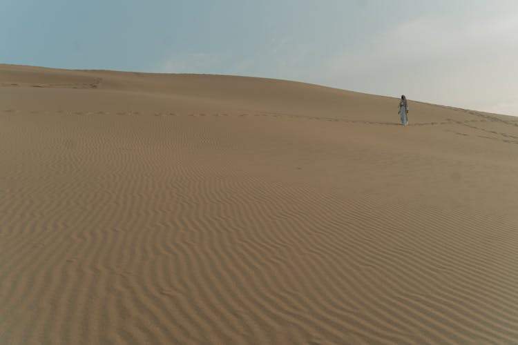 A Person Walking At The Desert