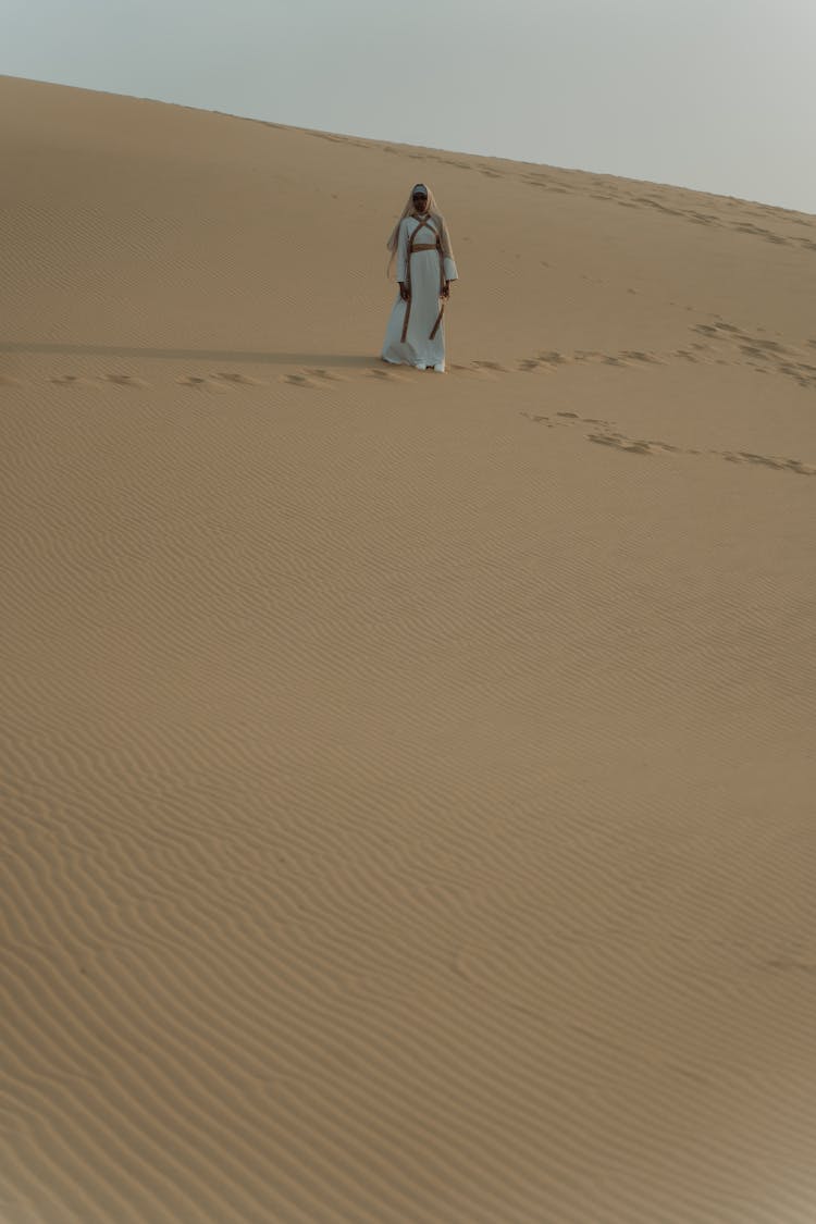 A Person Walking At The Desert