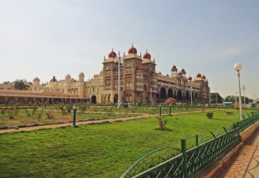 Majestic view of the Mysore Palace surrounded by lush green gardens in Karnataka, India.