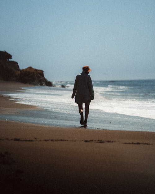 Free A Woman Walking on Beach Stock Photo