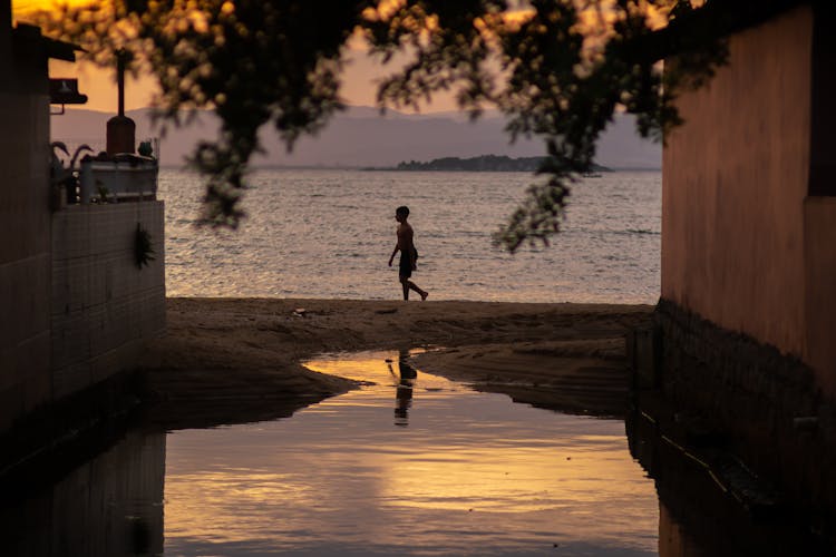 A Boy Walking On Shore