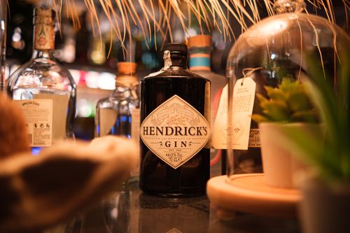 Free Hendrick's gin bottle on display at a cozy bar, surrounded by decor and glassware. Stock Photo