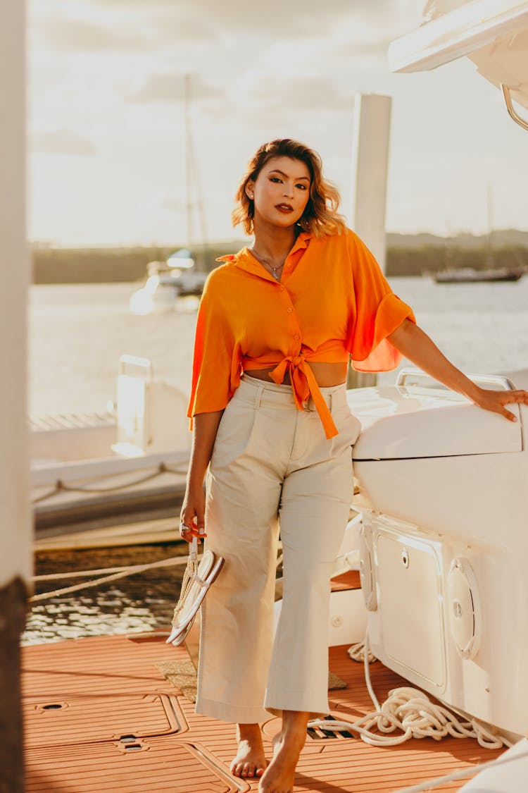 Woman In Orange Shirt Standing On Boat