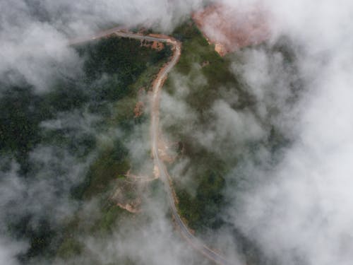 View of a Road between Forests from above the Clouds 