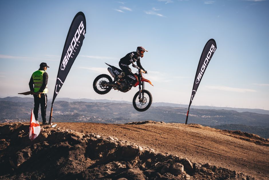 Exciting motocross jump captured against a scenic backdrop during a race.