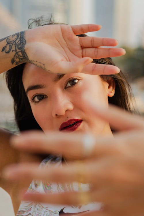 Free Woman with Tattoo Covering Face with Hand Stock Photo