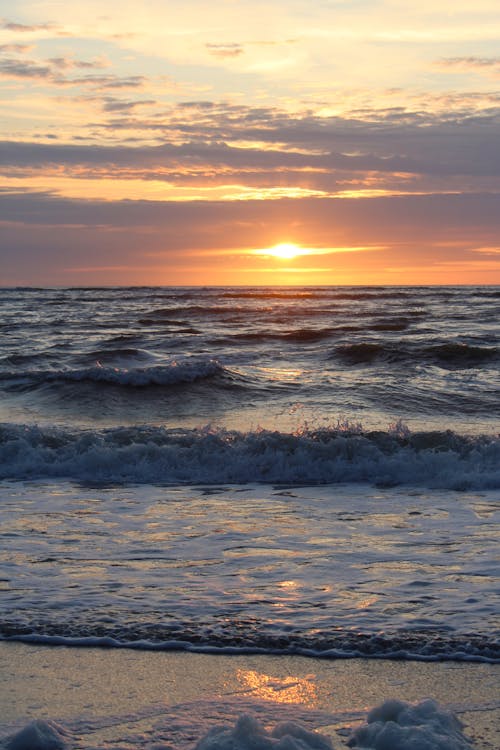 Ocean Waves Crashing on Shore During Sunset