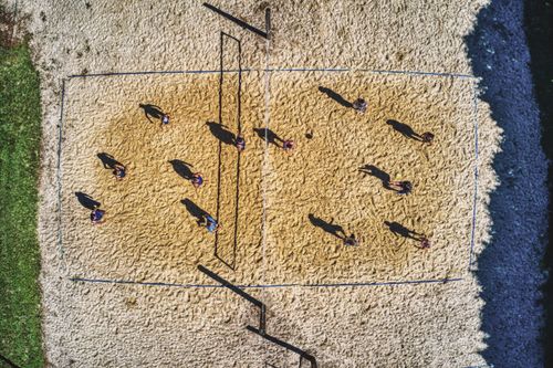 Free High-angle shot of people playing beach volleyball in Plainview, MN with vivid sunlight and shadows. Stock Photo