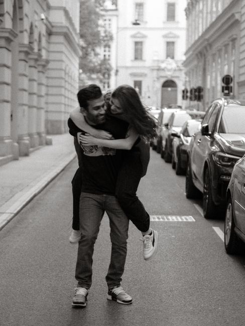 A happy couple enjoys a piggyback ride in a classic city street setting, sharing joy and connection.