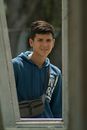 Portrait of a Young Man Wearing a Sling Bag and a Blue Hoodie