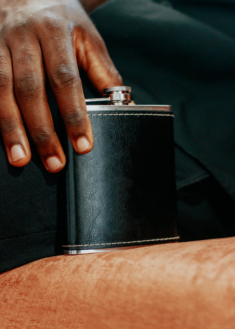 Person Holding Black Leather Liquor Flask