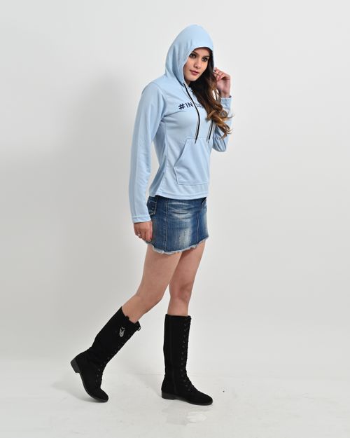 Free A woman posing in a blue hoodie and denim skirt during a studio photo shoot. Stock Photo