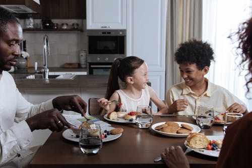 Free Family Eating Breakfast by Table Stock Photo