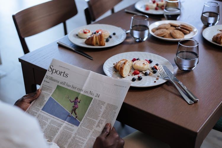 Rear View On Man Reading News About Tennis