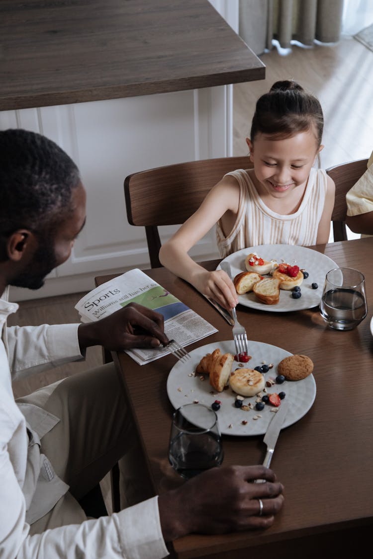 Young Girl Eating Breakfast with Dad