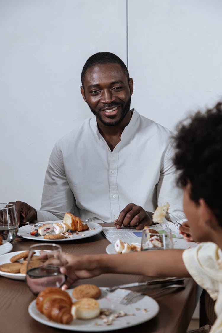 Dad Smiling While Looking At Son Taking Glass Of Water