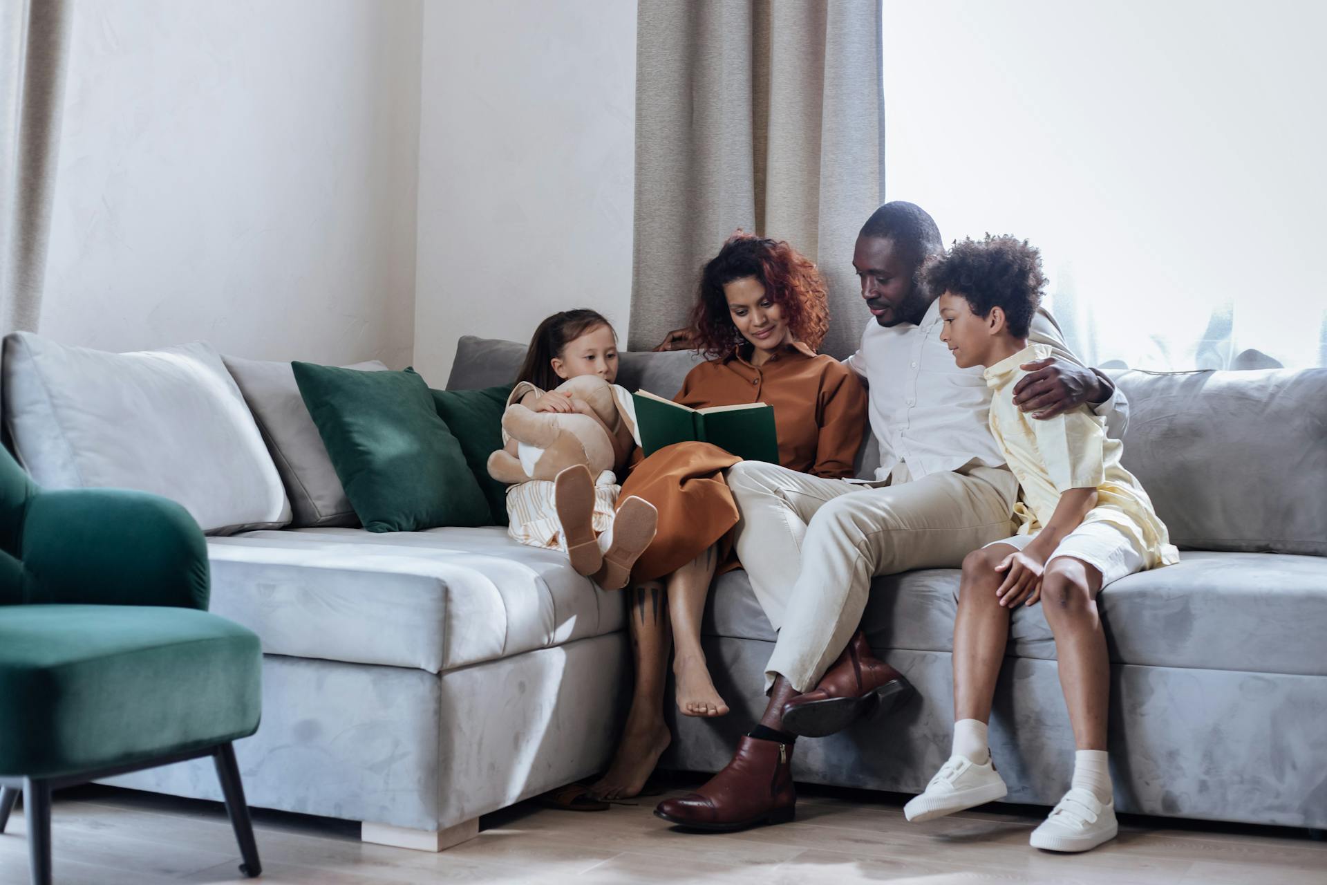 Family enjoying story time on a cozy sofa, nurturing bonds and imagination.