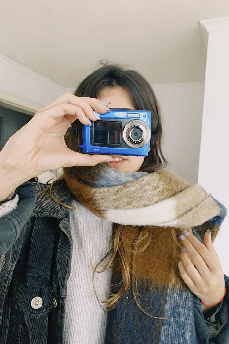 A Female Holding An Analog Camera In Her Face 