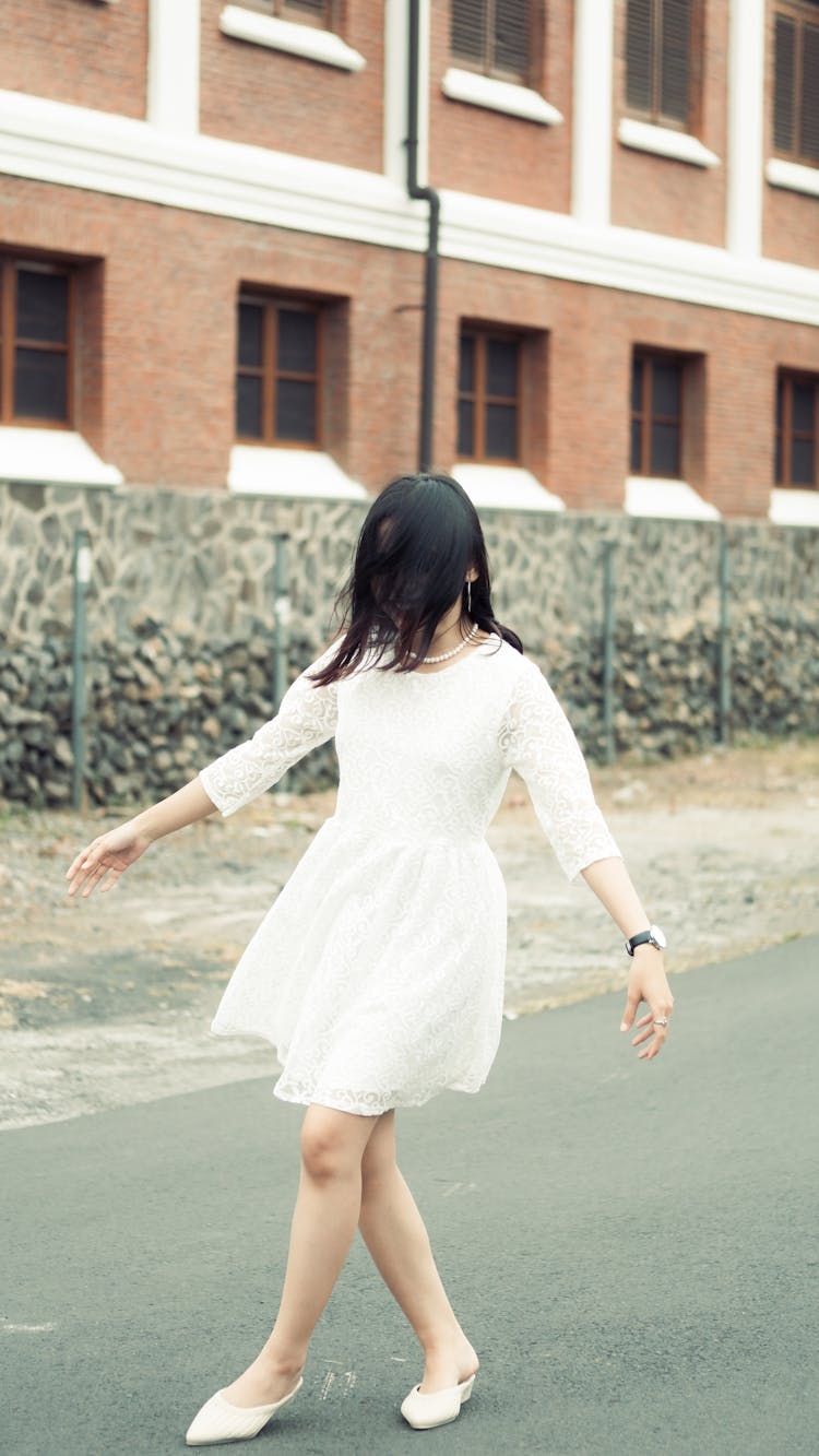 Woman In White Dress Walking On Street