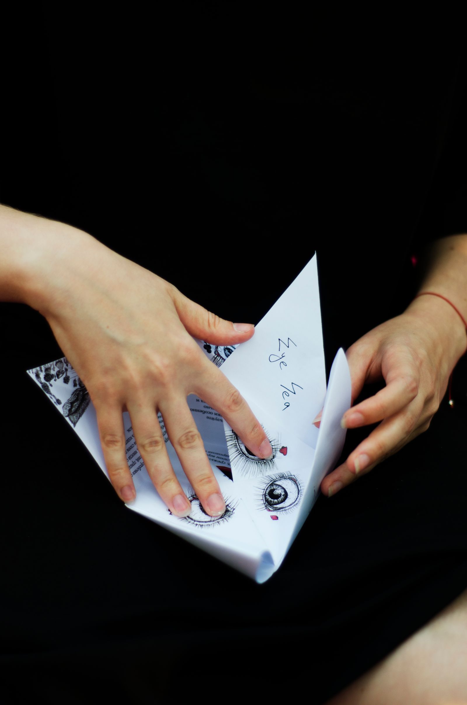 Mãos trabalhando nas dobras de uma peça de papel decorado.