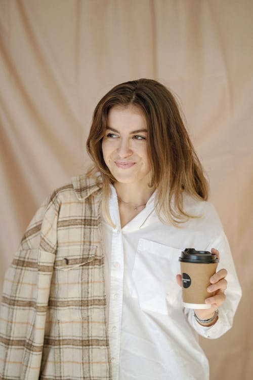 Woman Holding Coffee Cup and Smiling
