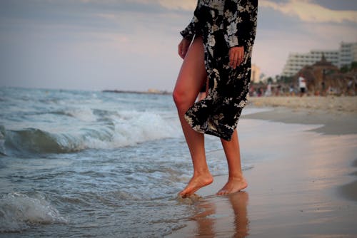 Photo of a Person Feeling the Water at the Beach