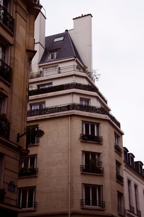 Free Elegant facade of a Parisian apartment building with classic architectural details. Stock Photo