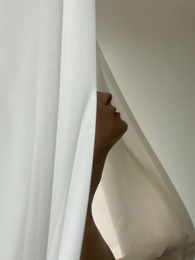 Womans Face Hidden By Curtain