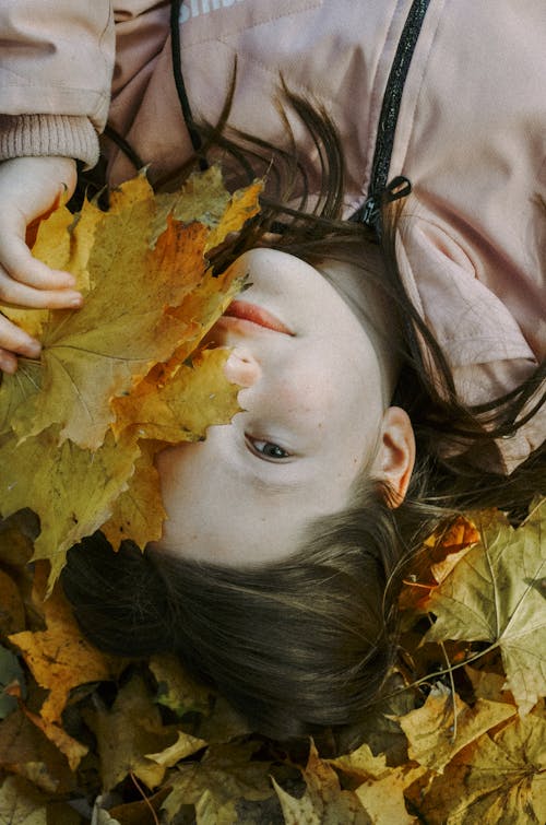 Young Girl Covering Face with Leaves