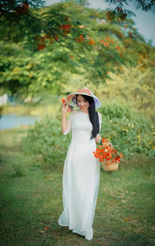 Foto profissional grátis de chapéu cônico asiático, flores, mulher