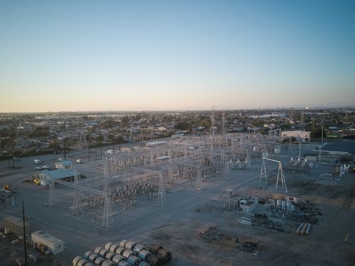 Free A wide view of a power station showcasing industrial infrastructure under a clear sky at sunset. Stock Photo