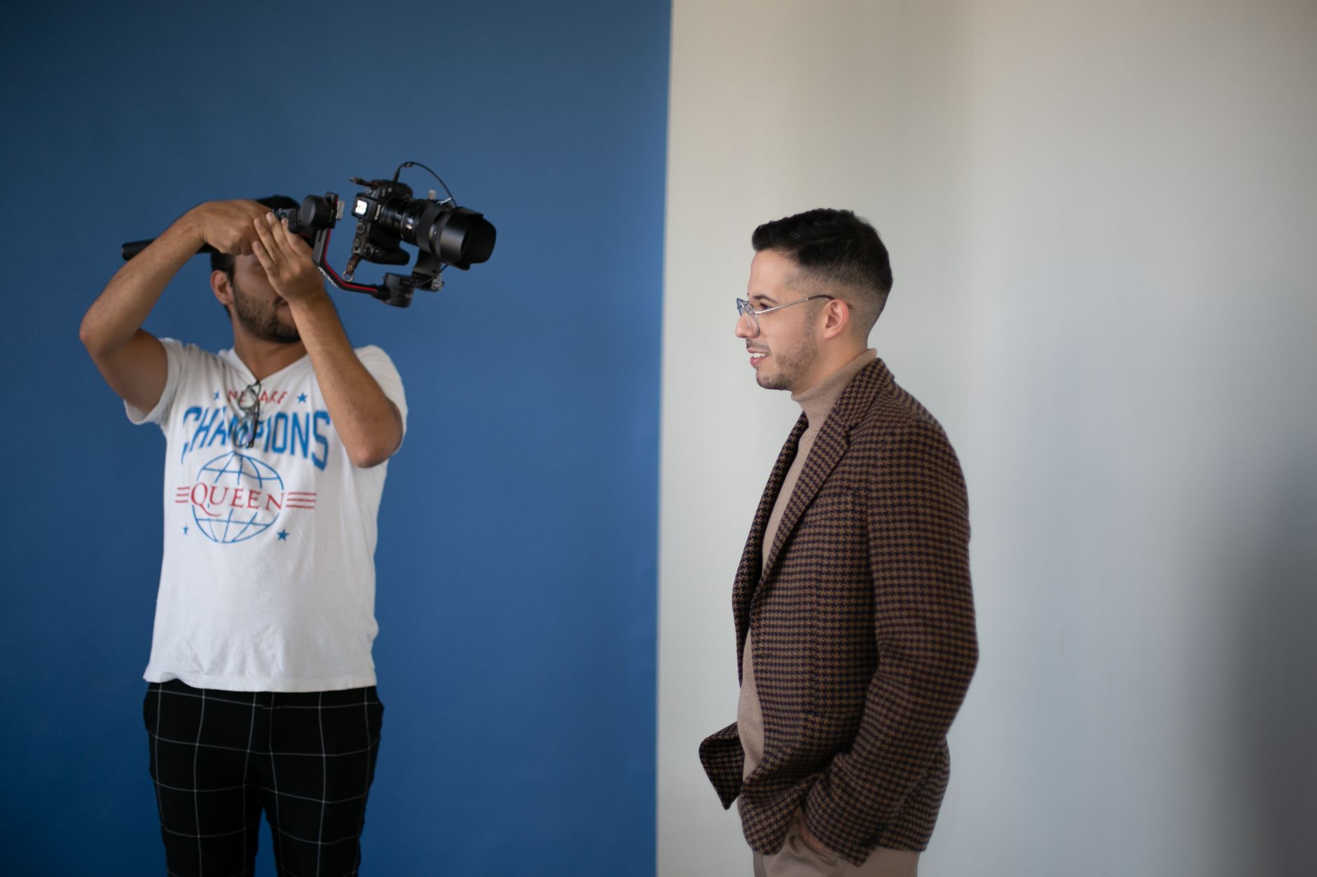 Behind-the-scenes shot of a video shoot with two men using a professional DSLR camera.