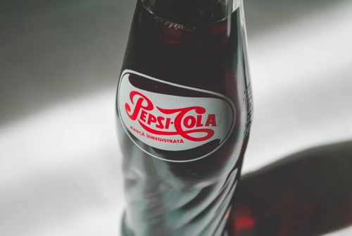Free Close-up of a classic Pepsi-Cola glass bottle showcasing its distinctive logo. Stock Photo