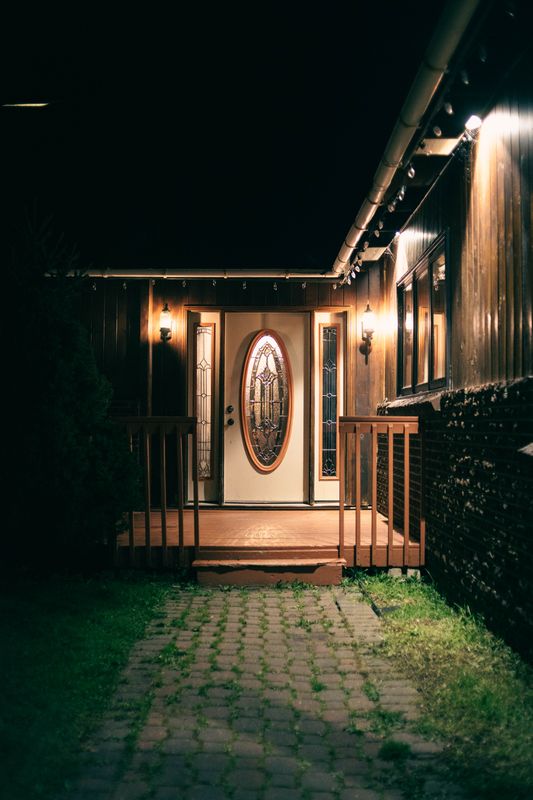 A lit front porch and steps at night - Brotherly Kindness, One Step from the Top