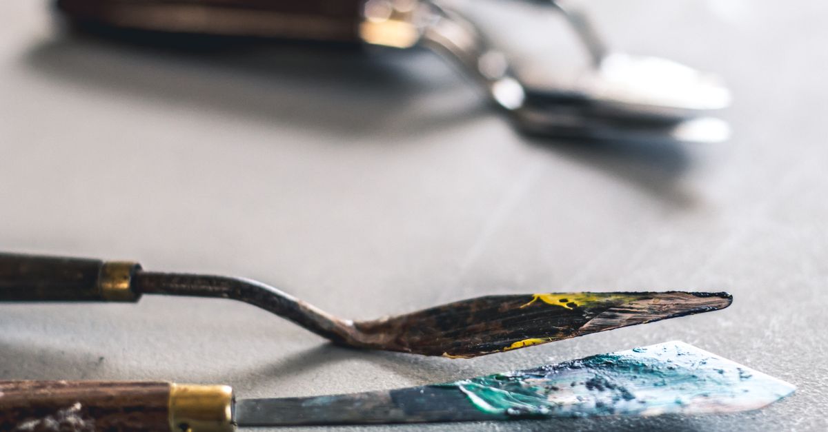Detail shot of paint palette knives with paint, perfect for art and craft themes.
