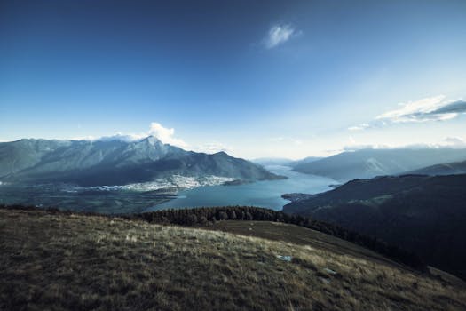 Stunning landscape of a mountain range with a clear blue sky and lake view.