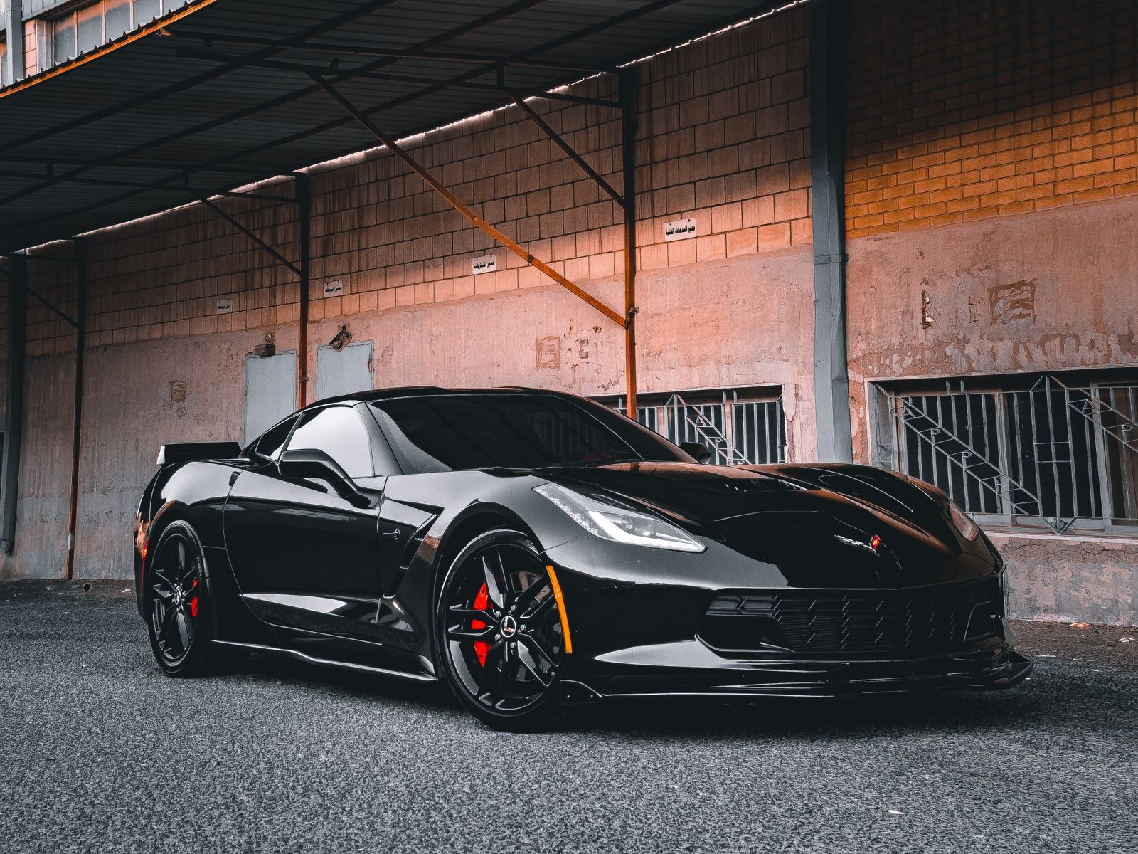 Black sports coupe inside a dark automotive studio