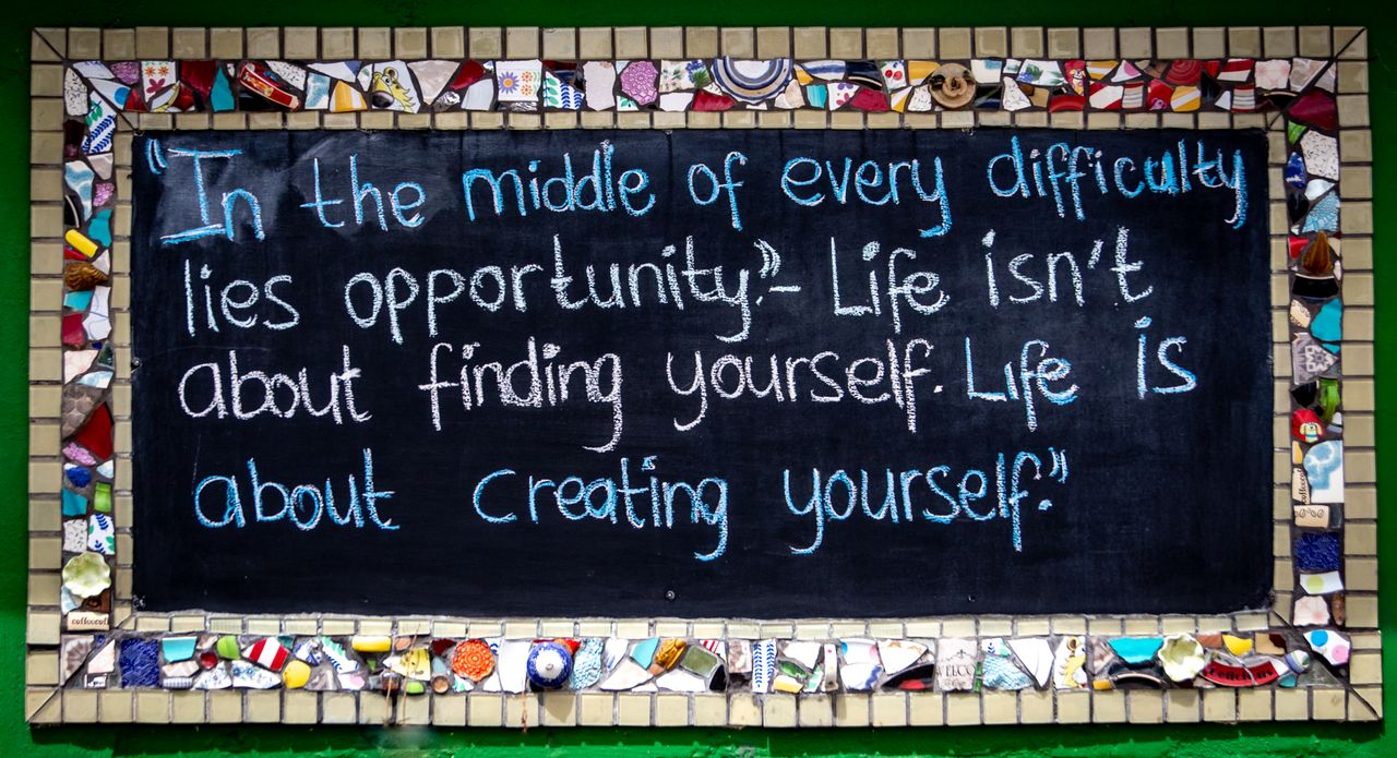 chalkboard with inspiring quote surrounded by vibrant mosaic pieces