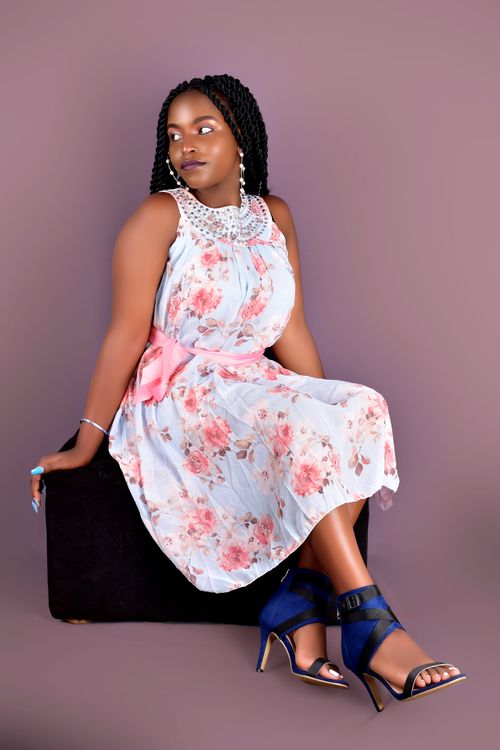 Free Young woman posing elegantly in floral dress during a studio photoshoot. Stock Photo