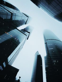 Low angle view of towering skyscrapers against a dramatic sky, capturing urban architecture.