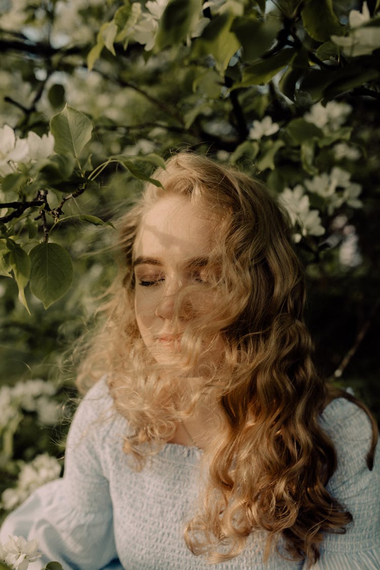 Blonde Wavy-haired Woman Among Green Leafs