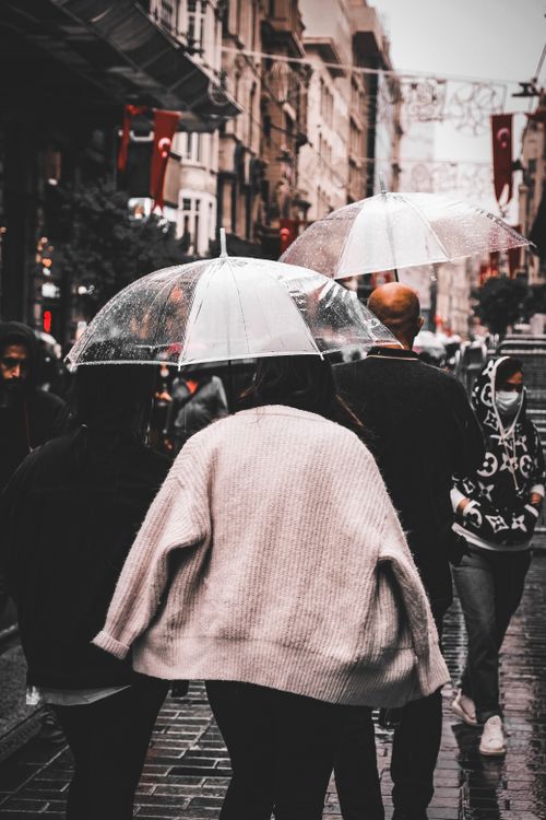 Free People walking under umbrellas on a rainy day in Istanbul's bustling Istiklal Street. Stock Photo