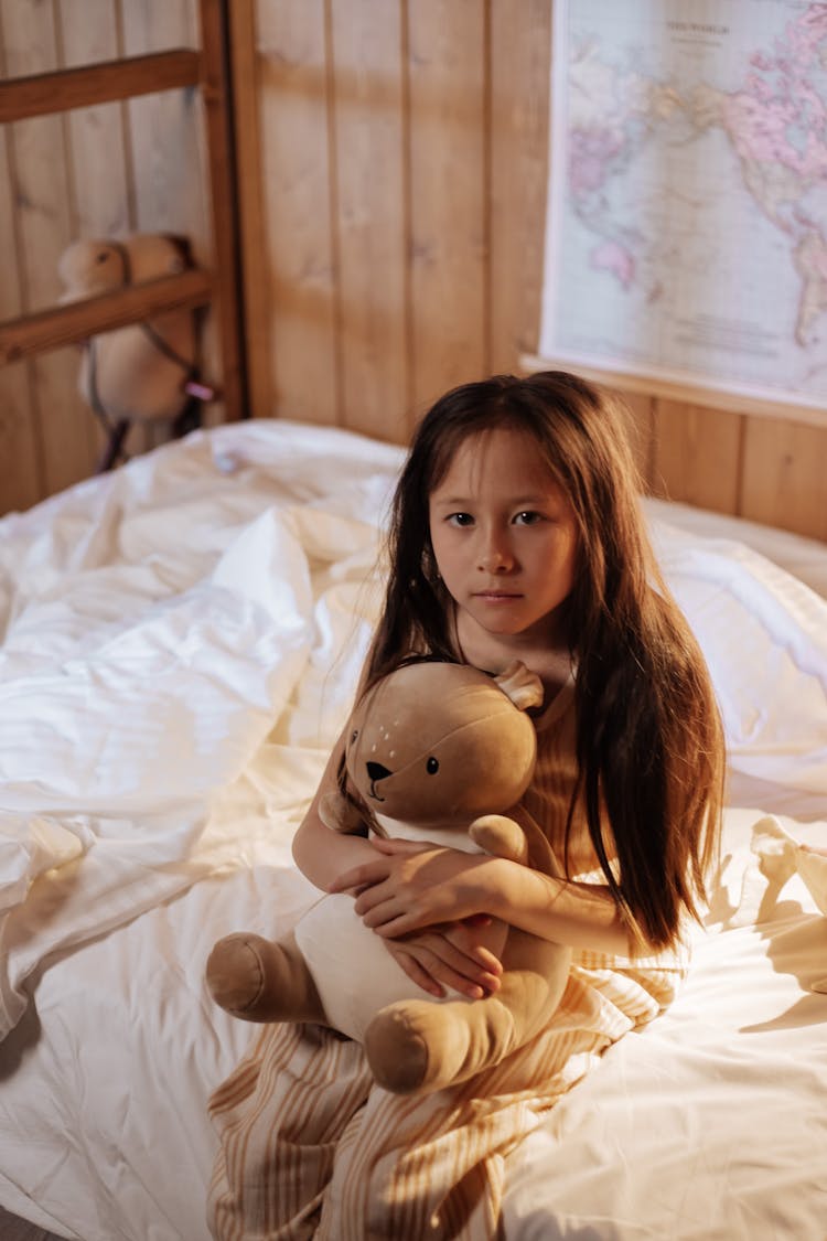 Portrait Of Sick Girl Sitting On Bed