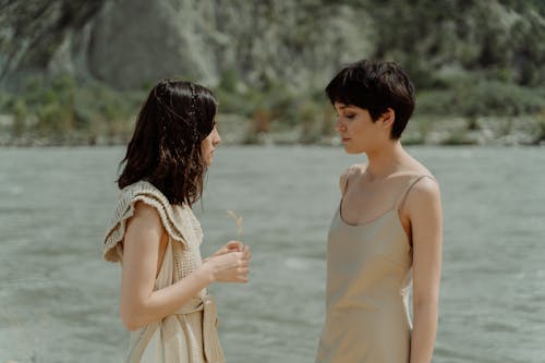 Brunettes Wearing Beige Standing by a River