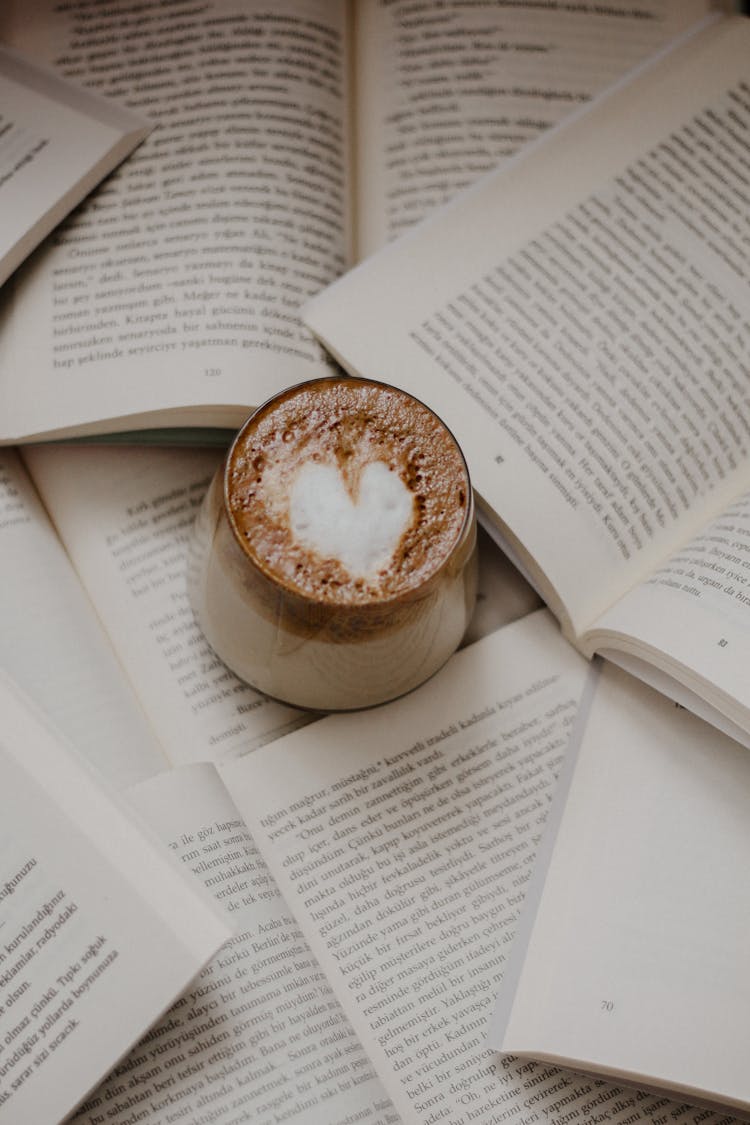 Cup Of Coffee On Opened Books