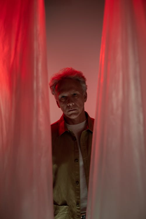 A Man Standing Behind Curtains
